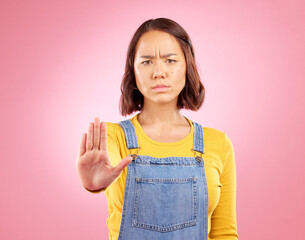 Woman, palm and stop in studio portrait with angry face, rejection or bad review by pink background. Gen z student girl, sign or emoji for protest, voice or opinion for feedback, activism or warning