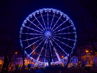Red tone illuminated colorful illuminated ferris wheel at night