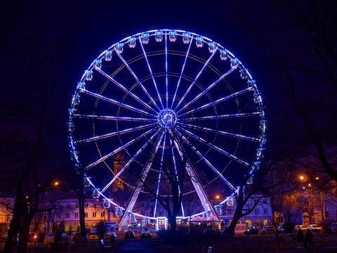 Red tone illuminated colorful illuminated ferris wheel at night
