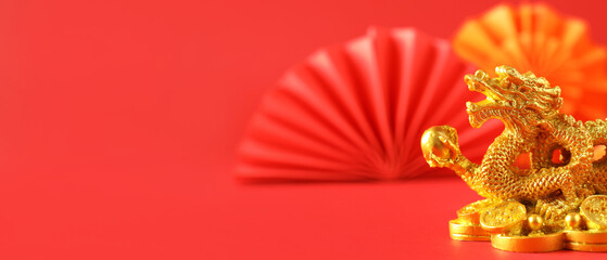 Golden figurine of Chinese dragon on red background with space for text