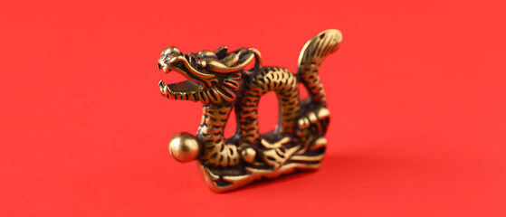 Bronze figurine of Chinese dragon on red background