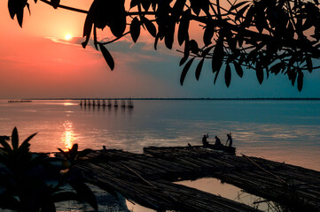Sunset at the river.  Silhouette of a tree and Fishermen at Brahmaputra River. Dibrugarh, Assam,...