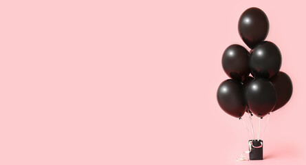 Balloons and shopping bag on pink background with space for text. Black Friday sale