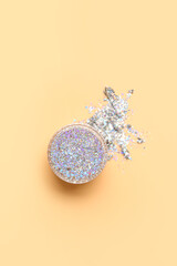 Jar of silver glitter on beige background