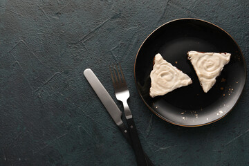 Plate of tasty sandwiches with cream cheese on black background