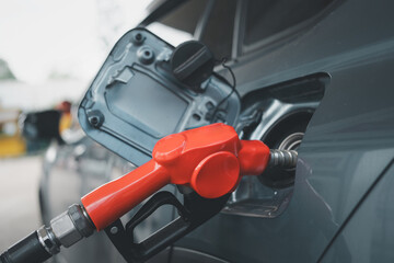 Car fueling at gas station. Petrol pump filling fuel nozzle in fuel tank of car at gas station....