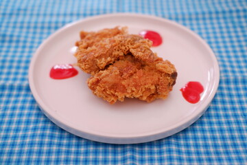 Crispy fried chicken on a plate with sauce, stock photo