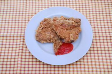 Crispy fried chicken on a plate with sauce, stock photo