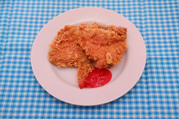Crispy fried chicken on a plate with sauce, stock photo