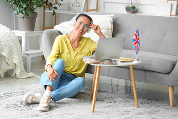 Mature woman with laptop studying English online at home