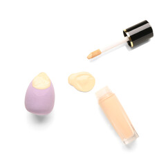 Bottle of makeup foundation with sample and sponge isolated on white background