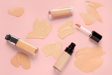 Bottles of makeup foundation with samples on pink background - obrazy, fototapety, plakaty