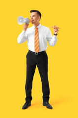 Handsome steward with wooden airplane shouting into megaphone on yellow background