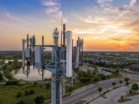 Aerial view of mobile phone cell tower by the road at sunset
