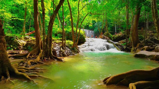 Waterfalls and fish swim in the emerald blue water in Erawan National Park. Erawan Waterfall is a beautiful natural rock waterfall in Kanchanaburi, Thailand.Onsen atmosphere
