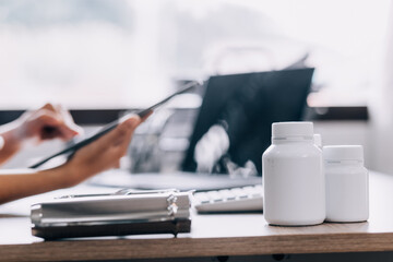 Concerned young female Caucasian doctor in white medical uniform sit at desk in hospital work on laptop, focused woman nurse or GP busy fill anamnesis on computer gadget, medicine, technology concept - obrazy, fototapety, plakaty