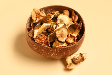 Brown bowl with tasty dried mushrooms on yellow background