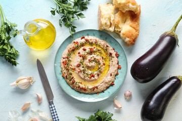 Plate of tasty baba ghanoush with ingredients on white background