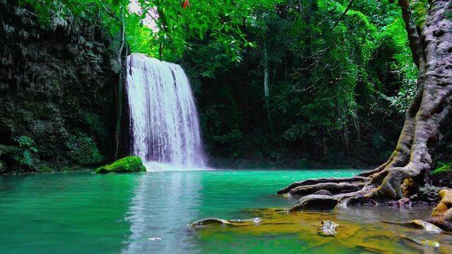 Waterfalls and fish swim in the emerald blue water in Erawan National Park. Erawan Waterfall is a beautiful natural rock waterfall in Kanchanaburi, Thailand.Onsen atmosphere