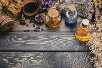 Obraz na płótnie Canvas Herbal medicine concept background. Dry natural ingredients and remedy bottle on the wooden table background with copy space. Top view. Witchcraft.