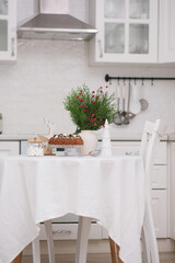 Christmas home interior in white kitchen-Christmas chocolate bundt cake with fresh berries and rosemary. Winter baking at Christmas. Ceramic vase with spruces brunches..