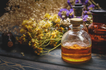 Herbal medicine concept background. Dry natural ingredients and remedy bottle on the wooden table background. Top view. Witchcraft.