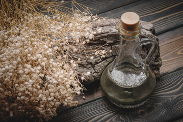 Herbal medicine concept background. Dry natural ingredients and remedy bottle on the wooden table...