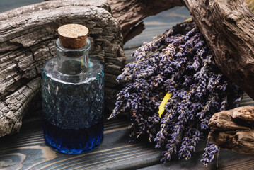 Herbal medicine concept background. Dried lavender flowers and remedy bottle on the wooden table...