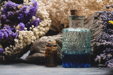 Herbal medicine concept background. Dried lavender flowers and remedy bottle on the wooden table...