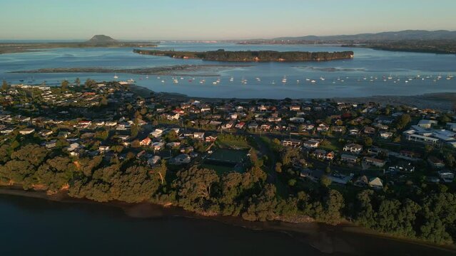 Sunset aerial view of coastal neighborhood in Akaroa, New Zealand, overlooking Mount Manganui