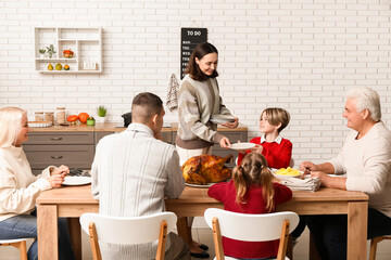 Happy family setting festive table at home on Thanksgiving Day