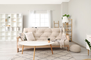 Interior of light living room with stylish sofa and coffee table