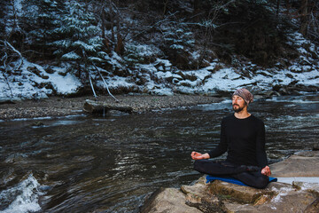 Motivation yoga and meditation on the wild nature near the river on the snow