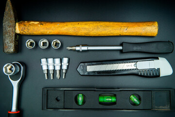 screwdriver hammer spirit level and bits isolated on black background
