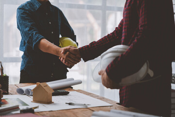Architect and engineer construction workers shaking hands after successful collaboration. working site, Construction, contract between two companies structure concept - obrazy, fototapety, plakaty