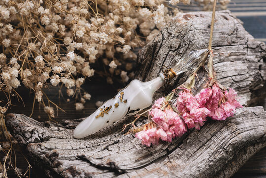 Perfume bottle and dried flowers close up background.