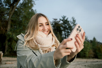 portrait of young woman taking selfie at lake