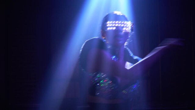 asian dancer in light fantasy costume dancing in night club