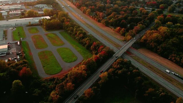 Incredible aerial of trucking logistics business, semi truck drivers on interstate. Sunset Fall season