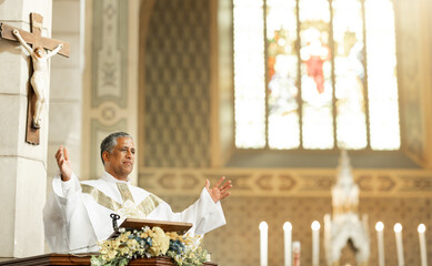 Religion, Christianity and priest speaking in church with arms raised standing by podium. Ceremony,...
