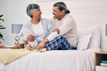 Fototapeta premium Old couple in bedroom together, hug with love and comfort, morning routine and happiness with bonding at home. Retirement, relax and communication, marriage and life partner with people in bed