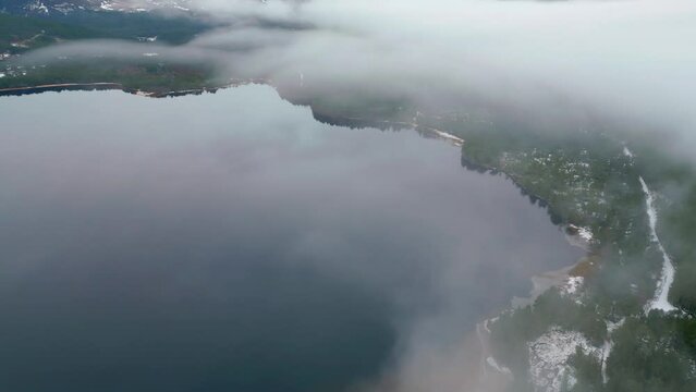 Mist shrouding Loch Ness and the surrounding by a snow capped landscape