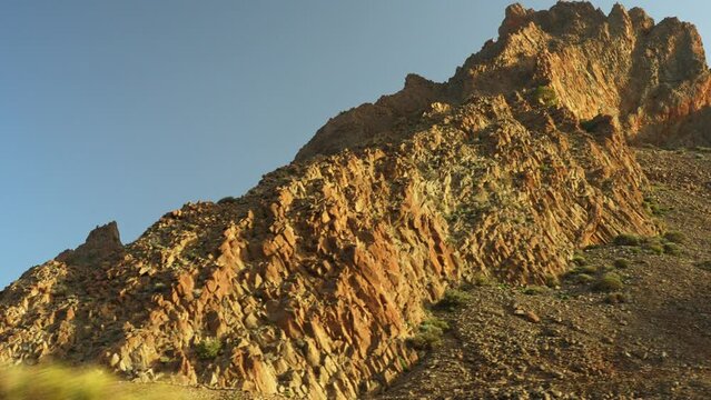 Driving near the rocky mountains at Teide National Park on Tenerife during sunset, pov closeup low angle