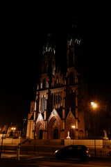 Roman Catholic cathedral, Gothic style architecture illuminated by night lanterns. Cathedral Basilica of the Assumption of the Blessed Virgin Mary. Białystok Cathedral, Bialystok, Poland 3 March 2021
