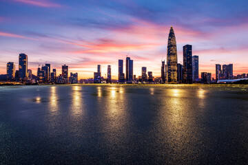 Asphalt road and urban skyline with modern buildings at sunset in Shenzhen, Guangdong Province, China.