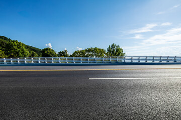 Fototapeta premium Highway and green tree landscape under blue sky