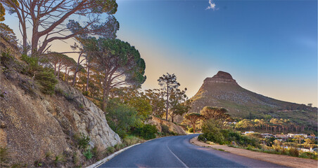 An empty road on the mountain at sunrise. Street overlooking mountain peak with a scenic view of...