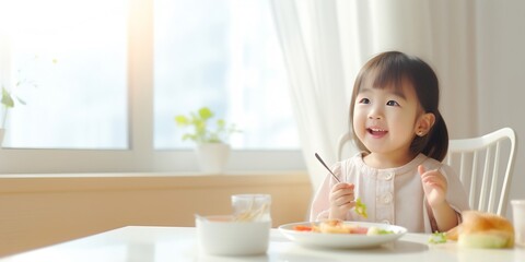 Asian cute little girl holding fork and trying to eat food sitting on the white high chair in the morning at home with copy space. : Generative AI - Powered by Adobe