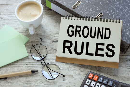 Ground rule. a cup of coffee. glasses. two office folder gray notepad. text on the page