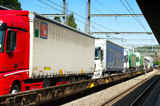 Spiez, Switzerland - July 25, 2019: With a rolling highway (rollende Autobahn) road trucks take the train to transport their cargo in the mountainous landscape